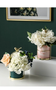 Detail of marble ceramic vases with gold bird frames and artificial floral bouquets
