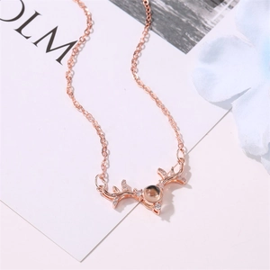 Macro detail of rose gold deer antler necklace with projection stone and tiny diamonds