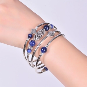 Close-up of layered turquoise wrap bracelet with vintage floral silver bead details