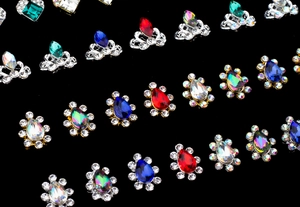 Macro shot of colorful oval crown nail gems with high-quality gold and silver settings