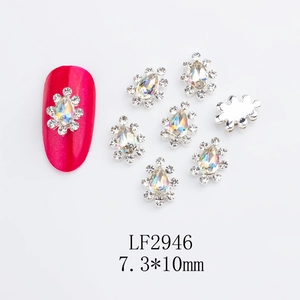 Silver crown-shaped nail art charms with K9 rhinestones and red manicure display
