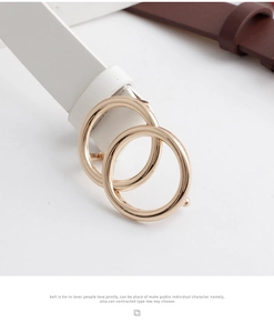 Detail view of the polished gold double-ring buckle on a white leather fashion belt