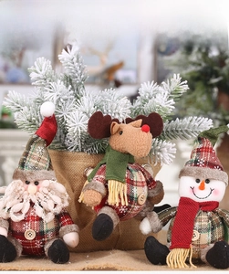 Detail of Christmas plush figurines featuring Santa, reindeer and snowman with plaid fabric