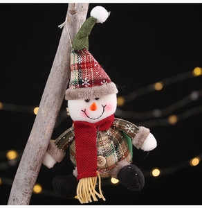 Detailed view of plush Christmas snowman ornament with red scarf on wooden stand