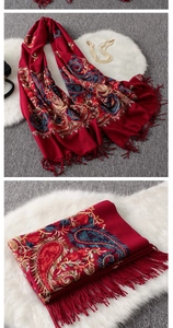 Macro detail of dark red cashmere-feel shawl with colorful paisley embroidery and fringe