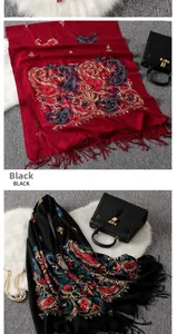 Detail of colorful paisley embroidery on premium cashmere-blend shawl with elegant tassels