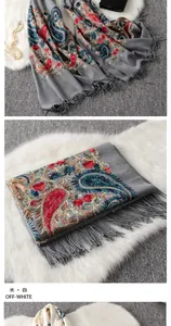 Detailed embroidery of paisley patterns and handmade fringe on off-white wool shawl