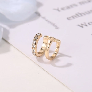 Macro shot of gold double-layer U-shaped ear cuffs with sparkling crystals details