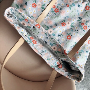 Close-up of floral tote bag with daisy pattern and premium leather shoulder strap