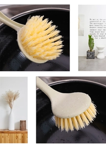 Detail of wheat straw cleaning brush with long handle and dense yellow bristles for pots