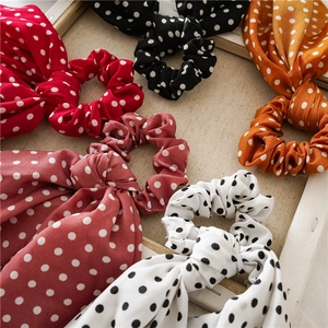 Close-up of colorful polka dot bow scrunchies in red, black, and orange chiffon fabric