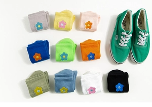 Flat lay of 10 pairs colorful cotton mid-calf socks with small flower embroidery details