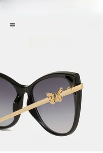 Detailed close-up of golden metal temples with elegant butterfly relief on cat-eye sunglasses