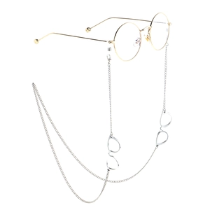 Silver eyewear chain with gold mini glasses pendant on white background