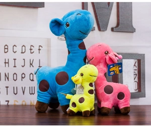 Detailed view of colorful plush giraffes in blue, pink, and yellow on a wooden surface