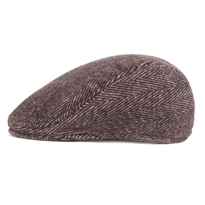 Close-up of brown herringbone fabric texture and stitching on the vintage flat cap