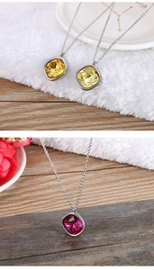 Close-up of three vibrant square-cut crystal pendants in yellow and pink on silver chains