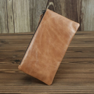 Gros plan du portefeuille long en cuir crazy horse marron sur une surface en bois