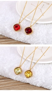 Detail of 13mm square zircon necklaces in vibrant red and yellow on luxury display
