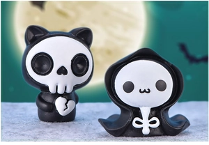 Close-up of cute Halloween resin figures featuring a black skeleton and a white ghost