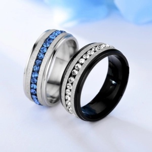 Close-up of titanium steel couple rings featuring inlaid blue and white crystal stones