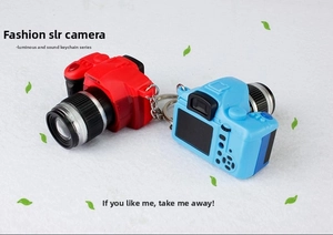 Close-up of SLR camera keychain with LED light and sound effects in red and blue colors