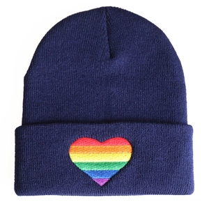 Close-up of rainbow heart embroidery on navy blue knitted beanie hat detail