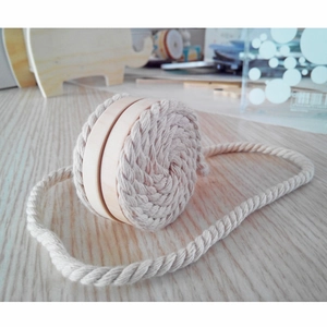Macro detail of wooden magnetic curtain tieback with woven cotton rope texture