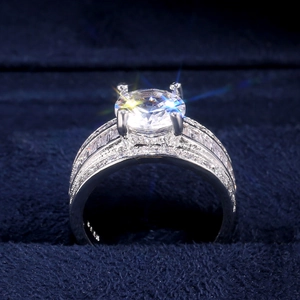 Dettaglio macro di un anello di lusso con zircone AAA, pietra rotonda e tagli a baguette