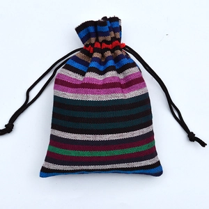 Detailed view of striped woven cotton drawstring bag with colorful ethnic patterns