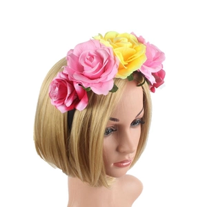 Detail of vibrant fabric roses in pink and yellow on a festive floral headband crown