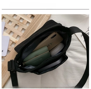 Detail view of black canvas crossbody bag interior compartments and large storage capacity