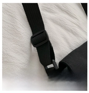 Detail of adjustable black nylon shoulder strap with matte plastic buckle on canvas bag