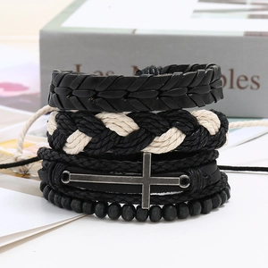 Detailed close-up of a four-piece men's braided leather bracelet set with a metal cross charm