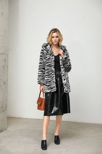 Detail of zebra stripe faux fur coat texture and long sleeves in a modern street style