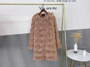 Detail of brown faux fur long coat with horizontal stripe design on a golden hanger