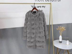 Detailed macro view of the fluffy grey faux fur texture on a long winter coat