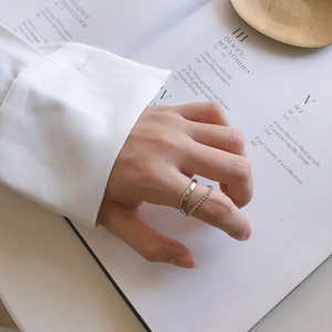 Close-up of minimalist 925 silver double-layer ring with wave band and metal bead chain