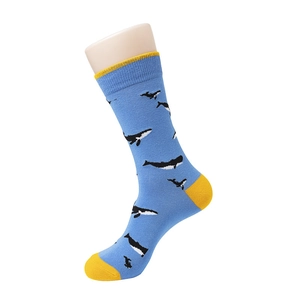 Detail of light blue crew socks featuring cartoon whale patterns and yellow contrast heels