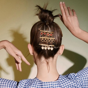 Detailed back view of model wearing vintage heart-shaped hair clips in red, black, and white
