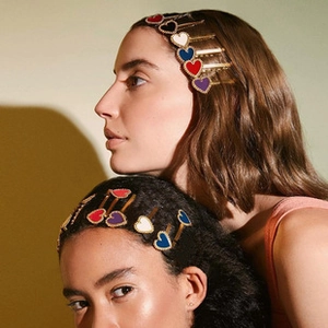 Detail view of colorful heart hair pins in red, white, blue and purple on model's hair