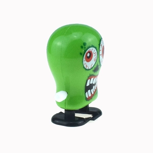 Dettaglio del mostro giocattolo verde a carica con occhi rossi e gambe meccaniche