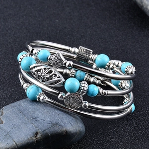 Bohemian multi-layer wrap bracelet featuring blue turquoise beads and floral silver charms