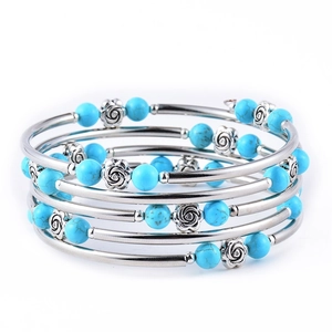 Macro shot of turquoise stone beads and silver rose charms on multilayer wrap bracelet