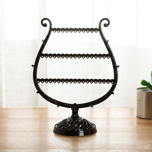 Detail of a 3-tier black harp-shaped jewelry stand with multiple holes for earrings