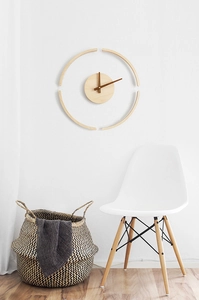 Minimalist wooden wall clock detail featuring curved wood segments on a white wall