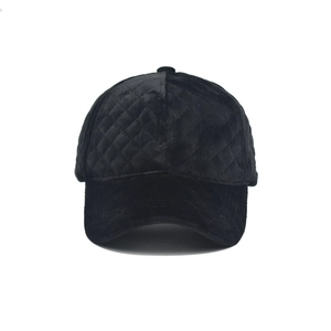 Detailed view of black velvet baseball cap featuring a classic quilted diamond pattern texture