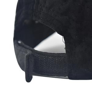 Adjustable back detail of a black corduroy baseball cap with breathable fabric and velcro strap