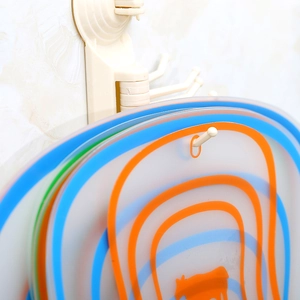 Flexible plastic cutting board set with wall-mounted suction cup hooks for kitchen storage