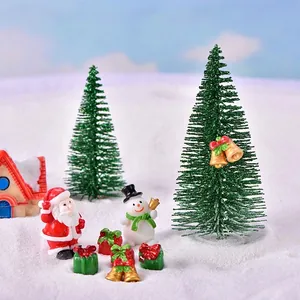 Miniature Christmas set with Santa, snowman, and pine trees on artificial snow